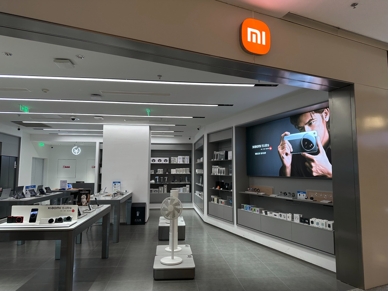 小米手机专卖店展示区，墙上大屏广告宣传Xiaomi 13 Ultra。